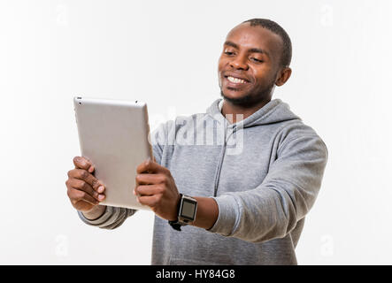 An African man uses a tablet in a studio environment. Stock Photo