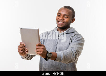 An African man uses a tablet in a studio environment. Stock Photo
