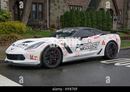 A recent model Corvette luxury automobile completely covered in advertisements. Parked ion Flushing, Queens, New York. Stock Photo