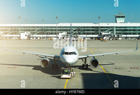 TUG Pushback tractor with Aircraft on the runway in airport. Stock Photo