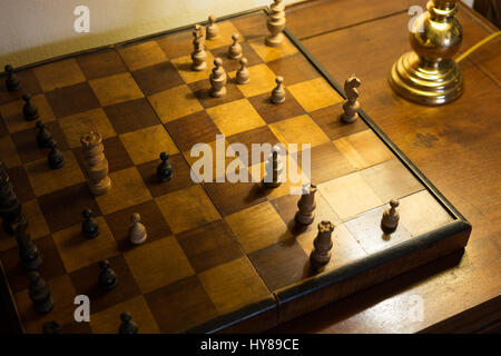 Old chessboard on writing desk and Soft Light of A desk Lamp Stock Photo