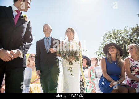 A proud father walks his daughter down the isle on her wedding day Stock Photo