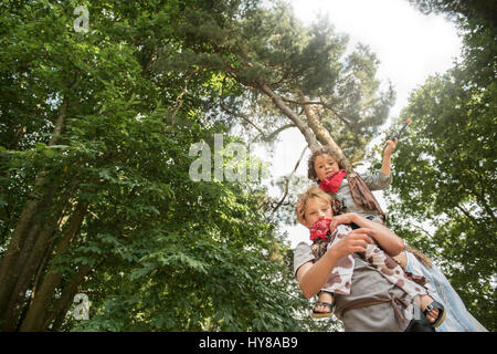 A young boy lifts up his friend whilst playing games in the sunshine Stock Photo