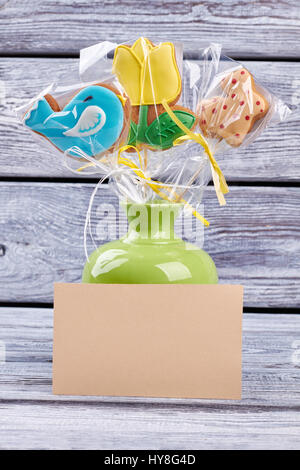 Cookies in vase, blank card. Three bright Easter biscuits. Stock Photo