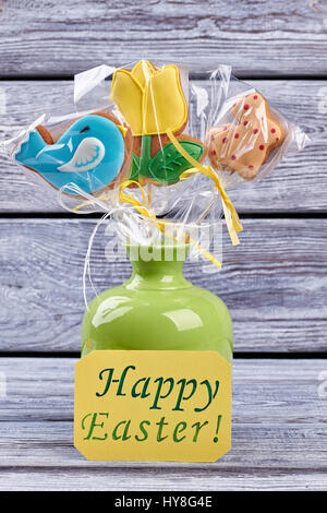 Vase with cookies, greeting card. Easter biscuits wrapped in plastic. Stock Photo