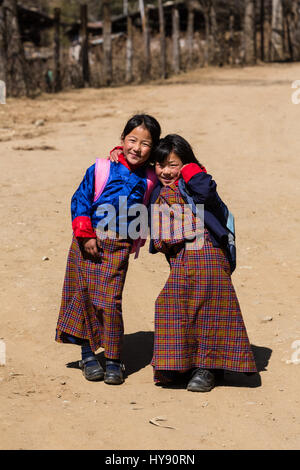 Two young girls in traditional Bhutanese dress walk to school in Hongtsho village in Bhutan. Stock Photo