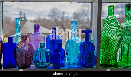 Close up colorful vintage bottle collection on a window shelf, interior antique shop, Hopewell, NEw Jersey, USa, US abstract still life, window sill Stock Photo