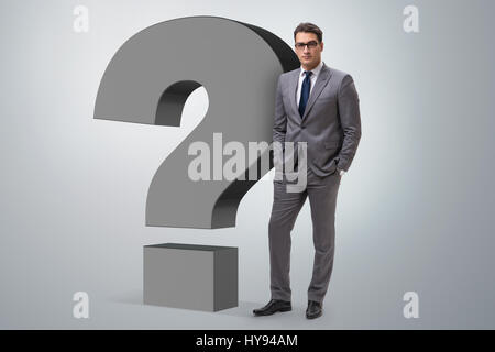 Businessman next to the giant question mark Stock Photo