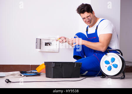 Funny Man doing electrical repairs at home Stock Photo