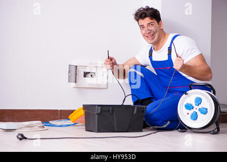 Funny Man doing electrical repairs at home Stock Photo