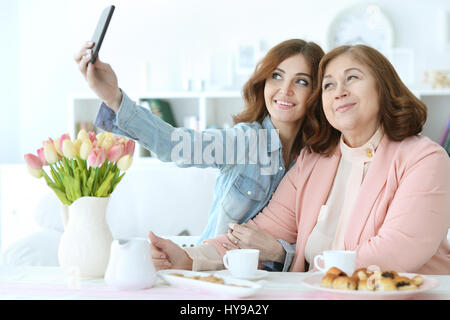 Daughter teaches an elderly mother to use a mobile phone Stock Photo
