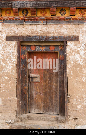 Traditional Bhutanese farm houses are built of packed mud, with very thick walls.  Punakha, Bhutan.  Detail of door. Stock Photo