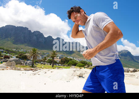 Portrait of a middle aged man walking on the beach in summer Stock Photo