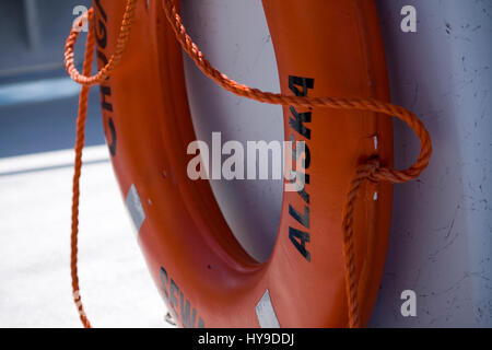 A ring-shaped orange floatation device on a tour boat in Seward, Alaska. Stock Photo
