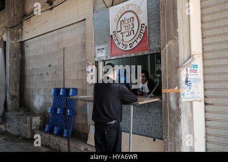 Kfar Chabad, Israel. 3rd April, 2017. A young woman sells hand made matzah through a window at the Chabad Matzah Bakery in the village of Kfar Chabad. Credit: Nir Alon/Alamy Live News Stock Photo