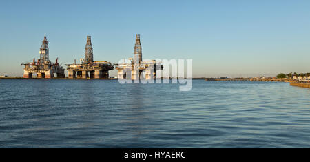 Deep water drill rigs temporarily in storage,  pm light, Harbor Island,  Canyon Port, Port Aransas to the right. Stock Photo