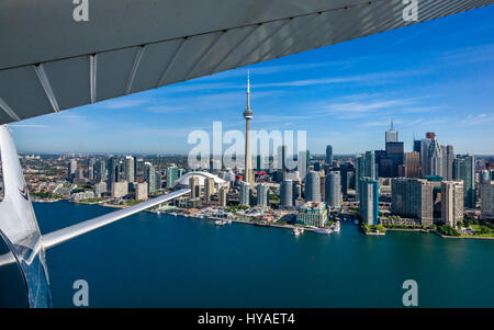 A view of the Toronto city skyline, showing exterior of airplane, after taking off from Billy Bishop Airport in downtown Toronto. Stock Photo