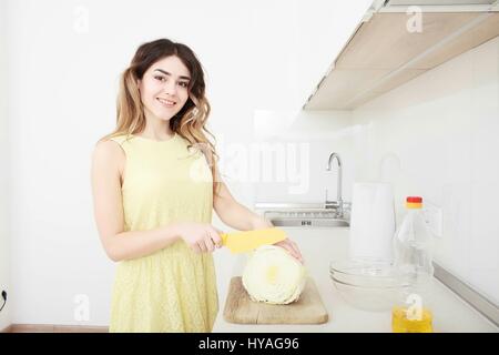 Girl cook cuts cabbage in the kitchen Stock Photo