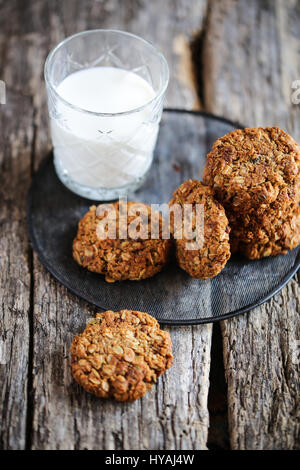 traditional anzac oat cookies and glass of milk on a wooden background Stock Photo