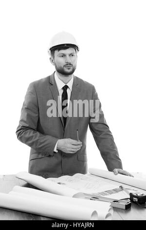 Mature male architect thinking while working on a blueprint Stock Photo