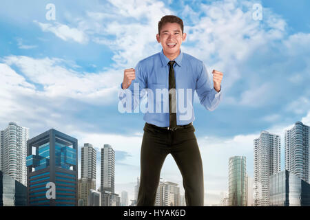 Happy asian businessman with spirit expression over skyscraper background Stock Photo