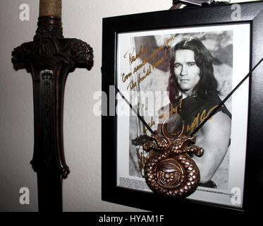 SACREMENTO, CALIFORNIA: Schwarzeneggar superfan Randy Jennings shows off his Conan sword and picture. THE WORLD’S number one Arnie superfan is celebrating his muscle-bound hero’s 67th birthday by revealing his Schwarzenegger shrine for the first time. From the carefully tending to his USD80K (£45K) collection of Arnold Schwarzenegger memorabilia to spending hours managing 90,000 new followers per month at his Arnie’s Army fansite – one superfan has made it his life’s mission to the Total Recall of his all-time idol. Since he was just eleven-years old and watched the legendary Arnie movie, Cona Stock Photo