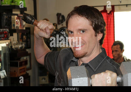 SACREMENTO, CALIFORNIA: Schwarzeneggar superfan Randy Jennings shows off his collection of Arnie memorabilia while playing with dumbells like his hero. THE WORLD’S number one Arnie superfan is celebrating his muscle-bound hero’s 67th birthday by revealing his Schwarzenegger shrine for the first time. From the carefully tending to his USD80K (£45K) collection of Arnold Schwarzenegger memorabilia to spending hours managing 90,000 new followers per month at his Arnie’s Army fansite – one superfan has made it his life’s mission to the Total Recall of his all-time idol. Since he was just eleven-yea Stock Photo