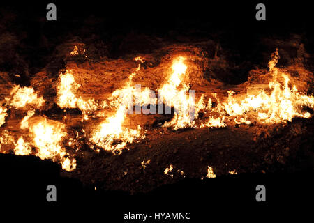 DERWEZE, TURKMENISTAN: Flames at the Door to Hell. THIS BRITISH honeymoon couple literally dragged each other to hell. Engineer Neil (34) and his bride Helen Melville-Kenney (36) took honeymooning in a hot location to next level when they decided to celebrate their new marriage by driving 3,000-miles from the UK to the real life 230-feet wide man-made crater. They drove in a Fiat Panda called Charlie. On arrival the happy couple can be seen having a flamin’ good time, with other visitors to the Derweze Gas Crater, known locally as the Doorway to Hell in Turkmenistan. Stock Photo