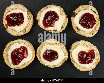 Scones With Clotted Cream and Strawberry Jam Against a Black Background Stock Photo