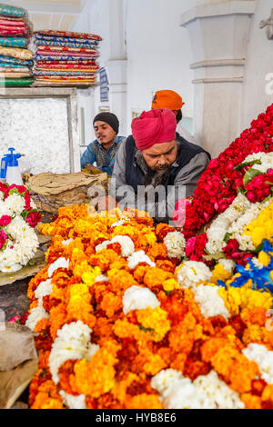 Volunteers selling marigolds as votive offerings at Gurudwara Bangla Sahib, a Sikh temple in New Delhi, capital city of India, near Connaught Place Stock Photo