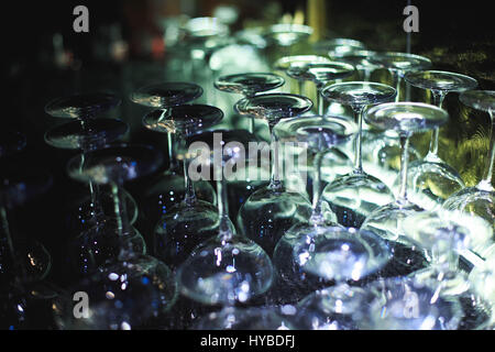 Inverted empty glasses arranged in several rows. The focus in the center of the frame Stock Photo