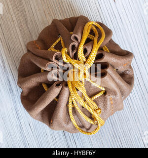 top view of tied leather purse for jewelry on wooden table Stock Photo