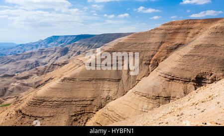 Travel to Middle East country Kingdom of Jordan - sedimentary mountains in valley of Wadi Mujib river (River Arnon) on ancient King's highway near Dhi Stock Photo