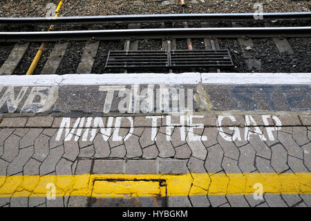 Mind The Gap painted on the edge of a train platform Stock Photo