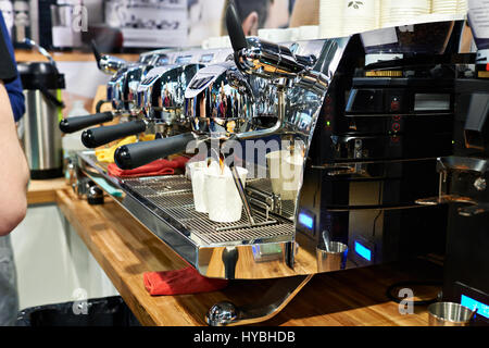 Large coffee machine pours two paper cups in cafe Stock Photo