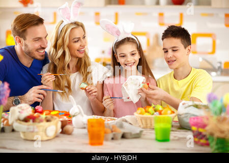 Happy family painting Easter eggs together Stock Photo