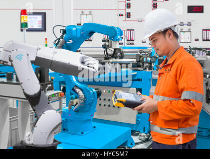 Maintenance engineer programing automated robotic at industry 4.0 concept Stock Photo