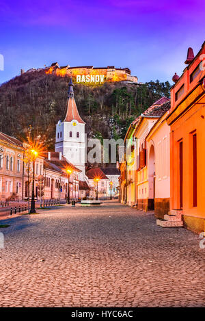 Rasnov, Romania. Evening twilight with medieval saxon city in Transylvania and hilltop ruins of the fortress. Stock Photo