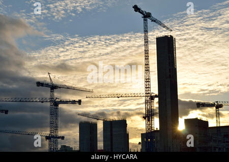 Silhouettes of cranes set against the evening sky on a construction site on the outskirts of Dublin city,Ireland. Stock Photo