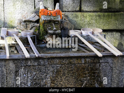 Chozuya purification fountain ladles. Traditional Japanese Shinto wash basin for ritual cleaningof worshipers at the shrine entrance. Stock Photo