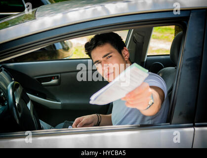 Man sitting in cat and giving docuemnts Stock Photo