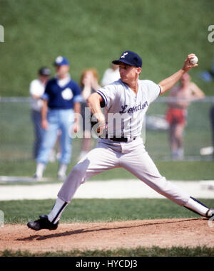 Pitcher in a baseball game  Baseball is a bat-and-ball game played between two teams of nine players each, who take turns batting and fielding. The batting team attempts to score runs by hitting a ball that is thrown by the pitcher with a bat swung by the batter, then running counter-clockwise around a series of four bases: first, second, third, and home plate. A run is scored when a player advances around the bases and returns to home plate. Players on the batting team take turns hitting against the pitcher of the fielding team, which tries to prevent runs by getting hitters out in any of sev Stock Photo