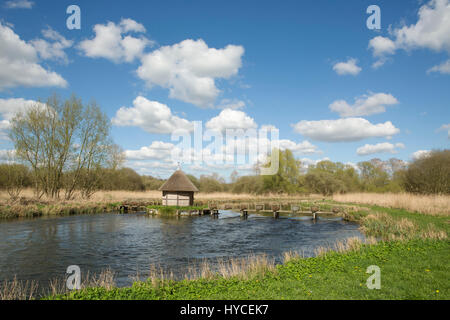 Trout fishery on the river Test in Hampshire. Crossing point with basket fish traps and a fisherman's hut. Stock Photo