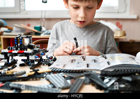 Little boy collects the children's plastic construction toys Stock Photo