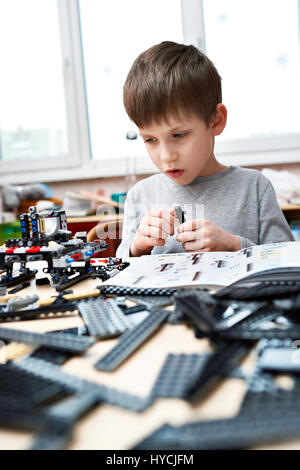 Little boy collects the children's plastic construction toys Stock Photo