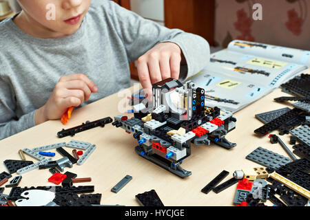 Little boy plays and collects the children's plastic construction toys Stock Photo