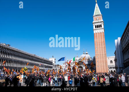 Celebrating the Saint's Day of Venice in the Piazza San Marco with flags and banners on a breezy sunny day Stock Photo