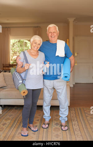 Active senior couple prepared for yoga standing together at home Stock Photo