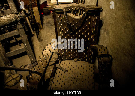 Old medieval torture chamber with a chair and tools Stock Photo
