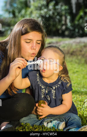 Sisters blowing bubbles/Down Syndrome Stock Photo